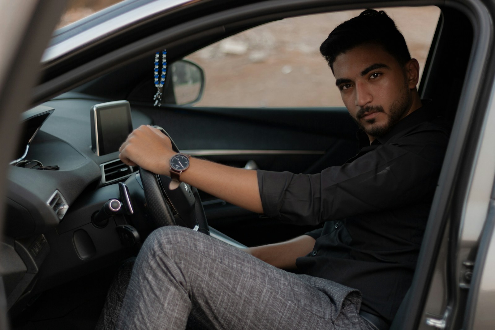 man in black jacket driving car